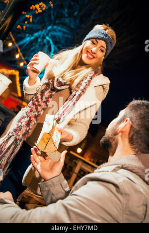 Junges Paar trinken Punsch am Weihnachtsmarkt Stockfoto