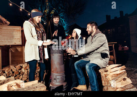 Vier Freunde, die Spaß am Weihnachtsmarkt Stockfoto