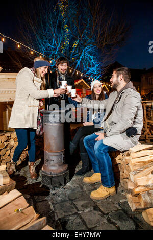 Vier Freunde trinken Punsch am Weihnachtsmarkt Stockfoto