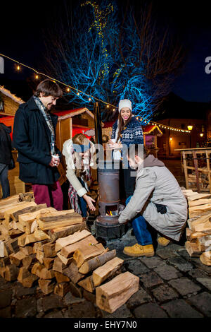 Vier Freunde Aufwärmen Ofen am Weihnachtsmarkt Stockfoto