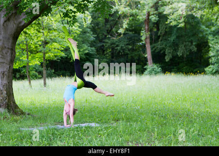 Junge Frau tut stretching-Übungen mit Gummiband, München, Bayern, Deutschland Stockfoto