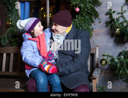 Großvater und Enkelin sitzen auf Bank, Bad Tölz, Bayern, Deutschland Stockfoto