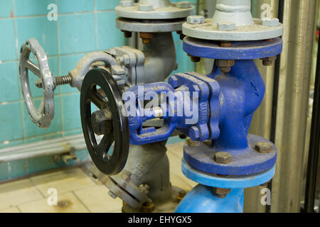 Rohre und Wasserhahnventile des Heizsystems in einem Heizraum Stockfoto