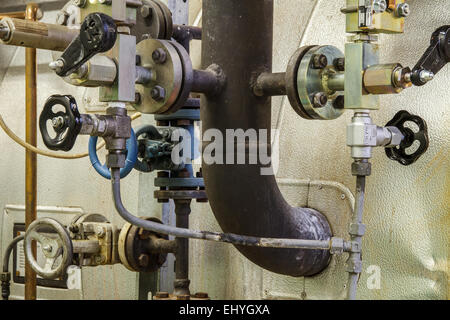 Rohre und Wasserhahnventile des Heizsystems in einem Heizraum Stockfoto