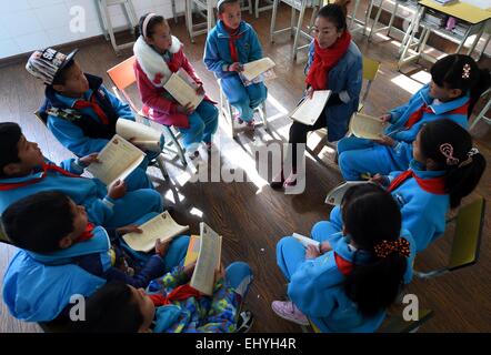 (150319)--DEQIN, 19. März 2015 (Xinhua)--Cili Zhoima (C) und Cili Yangzom (roter Mantel) Unterricht Englisch auf dem Spielplatz in Nr.-1-Grundschule in Deqin County, tibetischen autonomen Präfektur Diqing, Südwesten der chinesischen Provinz Yunnan, 17. März 2015. Ten-Year-Old Cili Zhoima und Cili Yangzom, Zwillingsschwestern tibetischen Volksgruppe wurden geboren, in einer gemeinsamen Familie in Deqin, eine schöne Gemeinde am Fuße der Meili Schnee Berg, mit einer durchschnittlichen Höhe von 6.000 Metern. Ihr Vater eröffnet ein Grill, während Mutter ein Landwirt ist. Zhoima, der ältere, bekommt gute Noten bei Stockfoto