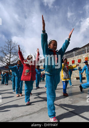 (150319)--DEQIN, 19. März 2015 (Xinhua)--Cili Zhoima (vorne) und Cili Yangzom (roter Mantel) tun Übungen auf dem Spielplatz in Nr.-1-Grundschule in Deqin County, tibetischen autonomen Präfektur Diqing, Südwesten der chinesischen Provinz Yunnan, 17. März 2015. Ten-Year-Old Cili Zhoima und Cili Yangzom, Zwillingsschwestern tibetischen Volksgruppe wurden geboren, in einer gemeinsamen Familie in Deqin, eine schöne Gemeinde am Fuße der Meili Schnee Berg, mit einer durchschnittlichen Höhe von 6.000 Metern. Ihr Vater eröffnet ein Grill, während Mutter ein Landwirt ist. Zhoima, der ältere, bekommt gute Noten bei scho Stockfoto