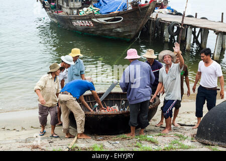 Einem anstrengenden Fisch Handel in den frühen Morgenstunden in der Nähe von Hoi an, Vietnam. Ein runder Korb-Stil-Boot. Stockfoto