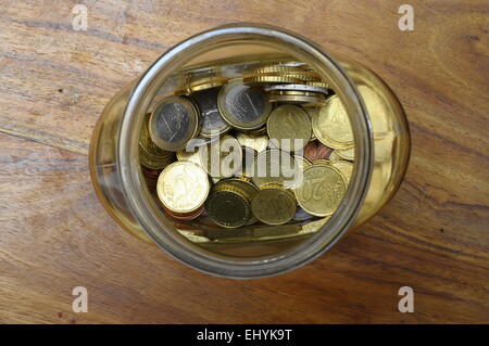 Euro-Cent in einem Glas jar als Sparschwein auf Holztisch Stockfoto