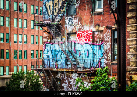 Graffiti und Treppen an der Seite ein Backsteinbau aus der Lesung-Viadukt in Philadelphia, Pennsylvania gesehen. Stockfoto