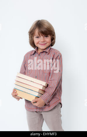 Junge hält einen Stapel Bücher Stockfoto