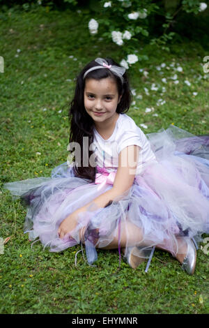 Mädchen, gekleidet in einem Tutu sitzen auf dem Rasen Stockfoto