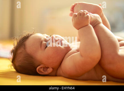 Baby Junge spielt mit Füßen Stockfoto