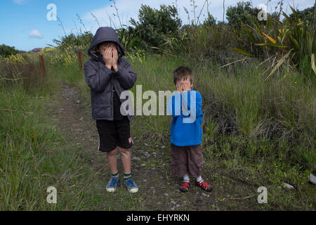 Kinder spielen verstecken und suchen im Feld Stockfoto