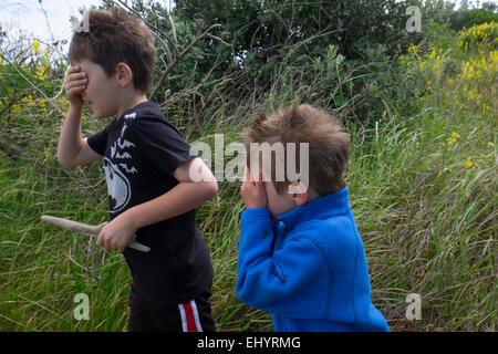 Kinder spielen verstecken und suchen im Feld Stockfoto