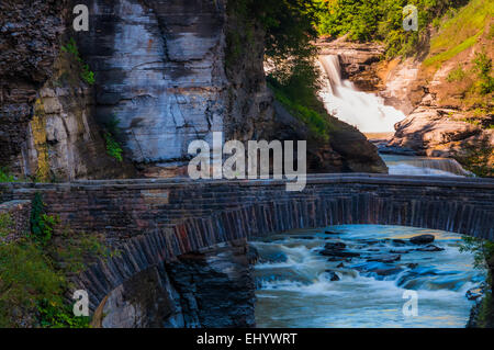 Lower Falls und eine Fußgängerbrücke über die Schlucht des Flusses Genesee, Letchworth State Park, New York. Stockfoto