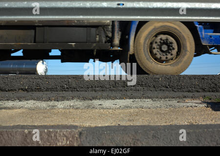 LKW-Räder zwischen dunklem Asphalt Straßen- und wachen. Bewegung erschossen Stockfoto