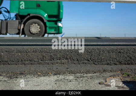 LKW-Räder zwischen dunklem Asphalt Straßen- und wachen. Bewegung erschossen Stockfoto