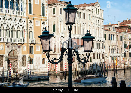 Straßenlaternen auf dem Canal Grande mit Bauten im venezianischen Stil. Stockfoto