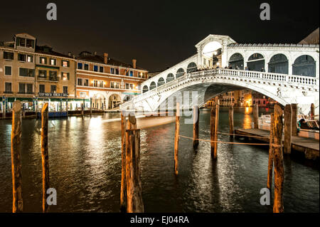 Pier mit Boot am Canal Grande bei der Rialto-Brücke in der Nacht. Stockfoto