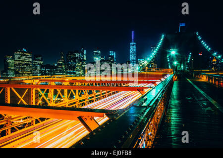 Die Skyline von Manhattan und den Verkehr auf die Brooklyn Bridge bei Nacht, New York. Stockfoto