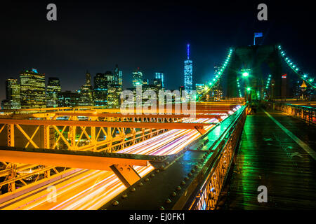 Die Skyline von Manhattan und den Verkehr auf die Brooklyn Bridge bei Nacht, New York. Stockfoto