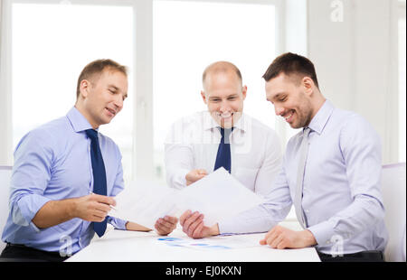 Lächelnde Geschäftsleute mit Papieren im Büro Stockfoto