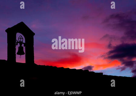 Silhouette des alten Glockenturm mit der letzten Lichtstrahl beleuchtet bei Sonnenuntergang, Montánchez, Spanien Stockfoto