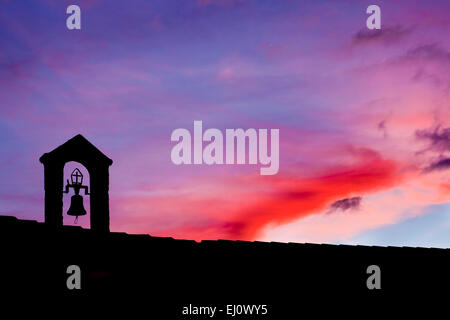 Silhouette des alten Glockenturm mit der letzten Lichtstrahl beleuchtet bei Sonnenuntergang, Montánchez, Spanien Stockfoto