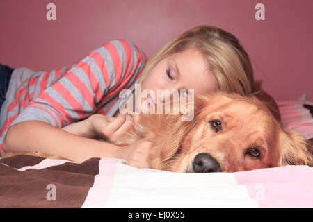 Mädchen und ihr Hund schlafen zusammen auf ein Schlafzimmer Stockfoto