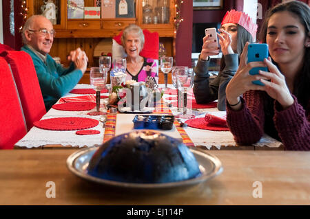 Horizontale Ansicht einen Christmas Pudding, flambierte während einer Familie Weihnachtsessen Stockfoto