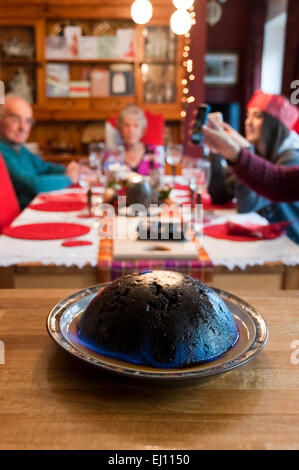 Vertikale Ansicht einen Christmas Pudding, flambierte während einer Familie Weihnachtsessen Stockfoto