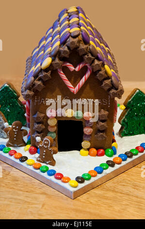 Vertikale Nahaufnahme eine hausgemachte Lebkuchenhaus zu Weihnachten mit Schnee und Weihnachtsbäume dekoriert. Stockfoto