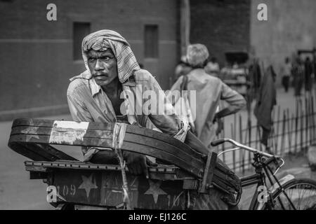 Zyklus Rickshaw Wallh ruht auf seinem Fahrrad außerhalb das Rote Fort in Delhi, Indien Stockfoto