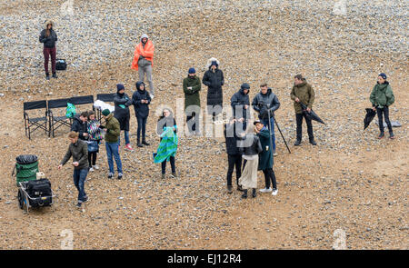 Gruppe der Angestellten und einem weiblichen Modell auf einem Strand für ein professionelles Fotoshooting in Großbritannien zusammengestellt. Stockfoto