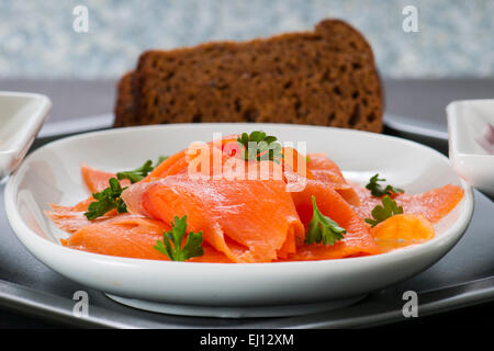 Geräucherter Lachs Lox-Plattenteller mit roten Zwiebeln, Roggenbrot und Frischkäse. Stockfoto