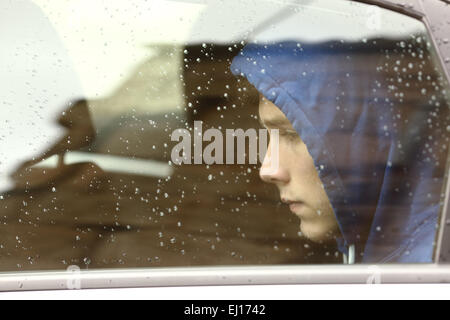 Traurige Teenager junge in einem Auto durch die Fenster schaut besorgt Stockfoto