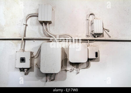 Blick auf eine alte weiße elektrische Netzwerk Kabel an der Wand. Stockfoto