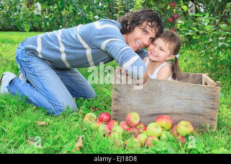 Vater spielt mit ihrer Tochter am Apfelbaum Stockfoto