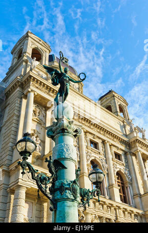 Eine weibliche Engel hält zwei Kränze in der Luft auf der Oberseite eine Vintage Laterne vor das Museum of Art History, Vienna. Stockfoto