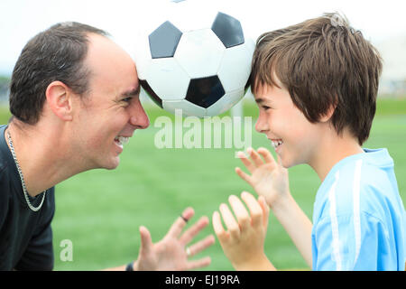 Ein junger Fußballer mit Vater Stockfoto