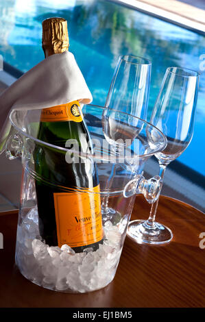 Veuve Clicquot feine Vintage Champagner-Flasche mit Brille, auf Eis in Weinkühler, Luxus sonnenbeschienenen Infinity-Pool hinter Stockfoto