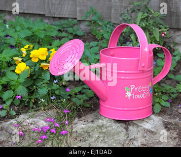 Des Kindes Gießkanne Rosa mit den Worten ziemlich Blumen auf der Seite geschrieben Stockfoto