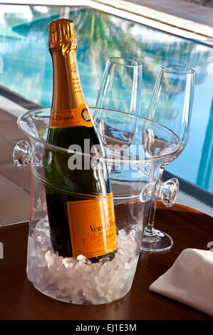 Veuve Clicquot feine Vintage Champagner-Flasche mit Brille, auf Eis in Weinkühler, Luxus sonnenbeschienenen Infinity-Pool hinter Stockfoto