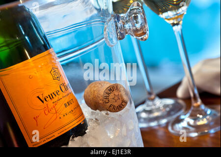 Schließen Sie die Ansicht auf Veuve Clicquot feine Flasche Champagner auf Eis mit Kork und Gläser, Luxus-Pool im Hintergrund Stockfoto