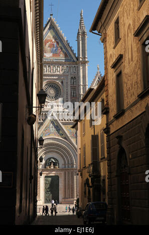 Die Menschen gehen vor der Kathedrale von Orvieto (Duomo di Orvieto) in Orvieto, Umbrien, Italien. Stockfoto