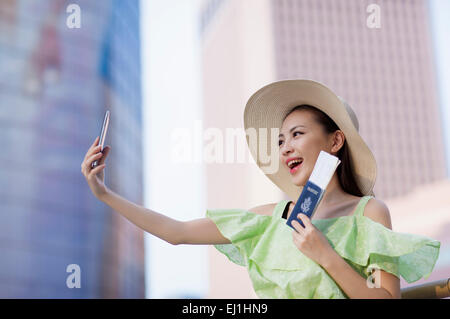 Aufnahme mit Handy und lächelnde junge Frau Stockfoto