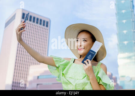 Aufnahme mit Handy und lächelnde junge Frau Stockfoto