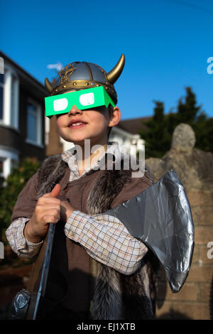 William, 7 Jahre alt, dauert einen Moment aus seinem Wikinger Kleid Tag südlich an die partielle Sonnenfinsternis in Cardiff, Wales. Klarem Himmel erlaubt eine gute Sicht auf den Mond Bedeckung 85 % des Kredits so.: Chris Stevenson/Alamy Live News Stockfoto