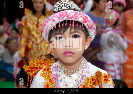 Ein Junge Burmesische gekleidet in bunten Gewändern und Puppe wie sein kommen der Alter Zeremonie in Mandalay Myanmar ausgleichen Stockfoto