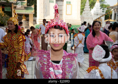 Ein Junge Burmesische gekleidet in bunten Gewändern und Puppe wie sein kommen der Alter Zeremonie in Mandalay Myanmar ausgleichen Stockfoto